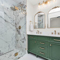 a bathroom with green cabinets and a marble shower