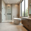 Modern spa bathroom with a soaking tub, rainfall shower, warm lighting, and a sleek vanity