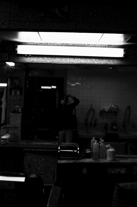 man in black t-shirt standing in front of mirror