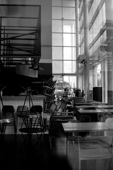 grayscale photo of empty chairs and tables