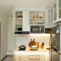 a kitchen with a refrigerator, stove, microwave, and cabinets