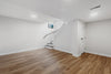 an empty room with a staircase and hard wood floors