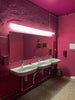 a pink bathroom with two sinks and a mirror