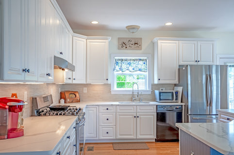 a kitchen with white cabinets and stainless steel appliances
