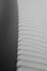 a black and white photo of a curved sand dune