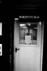 A black and white photo of a door and a sign
