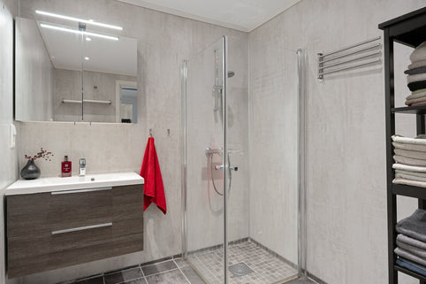 A bathroom with a stand up shower next to a sink