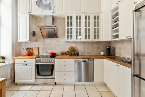 A kitchen with white cabinets and stainless steel appliances