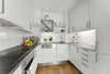 A kitchen with white cabinets and black counter tops