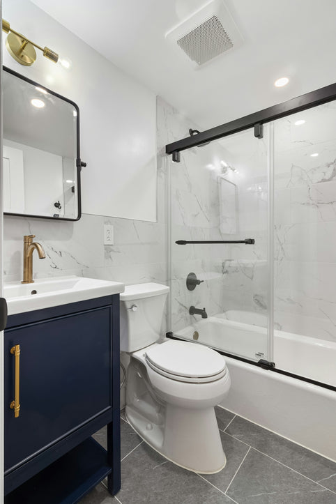 A bathroom with a toilet, sink, and shower
