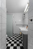 A black and white bathroom with a checkered floor