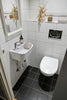 A bathroom with a toilet, sink and mirror