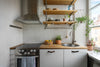 A kitchen with a stove top oven next to a window