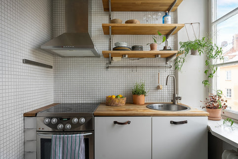 A kitchen with a stove top oven next to a window
