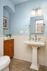 A bathroom with a toilet, sink, and mirror