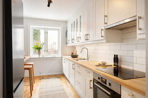 A kitchen with white cabinets and a stove top oven