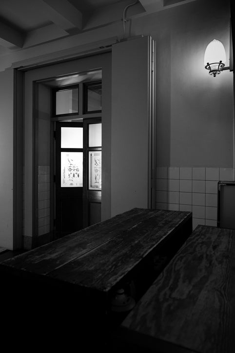 A dark room reveals light through a doorway.