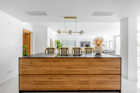 Modern kitchen island with chairs and decorative vase.