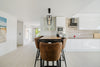 Modern kitchen island with brown chairs and sleek cabinets