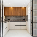 Modern white and wood kitchen with marble backsplash.