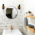 Modern bathroom with abstract face wallpaper and gold fixtures