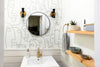 Modern bathroom with abstract face wallpaper and gold fixtures
