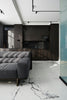 Modern living room with dark kitchen and marble floor