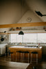 Modern kitchen island with bar stools and large window.