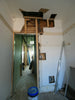 Interior room undergoing renovation with exposed walls and doorway