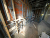 Interior construction with exposed pipes and framing