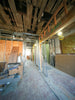 Interior hallway under construction with exposed ceiling and framing.