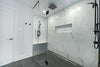 Modern bathroom with glass-enclosed shower and marble walls