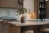 Modern kitchen island with decorative vases and faucet.