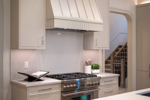 Modern kitchen with stainless steel stove and range hood.