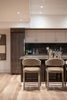 Modern kitchen island with two bar stools and wine cooler.