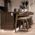 Modern kitchen island with bar stools and decorative vases.