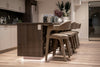 Modern kitchen island with bar stools and decorative vases.