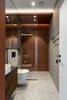 Modern bathroom with brown tiled shower and dark wood vanity.