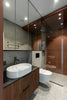 A modern bathroom with a sink, toilet, shower, and mirrors.