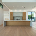Spacious modern kitchen with large island and light wood cabinets.