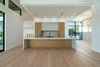 Spacious modern kitchen with large island and light wood cabinets.